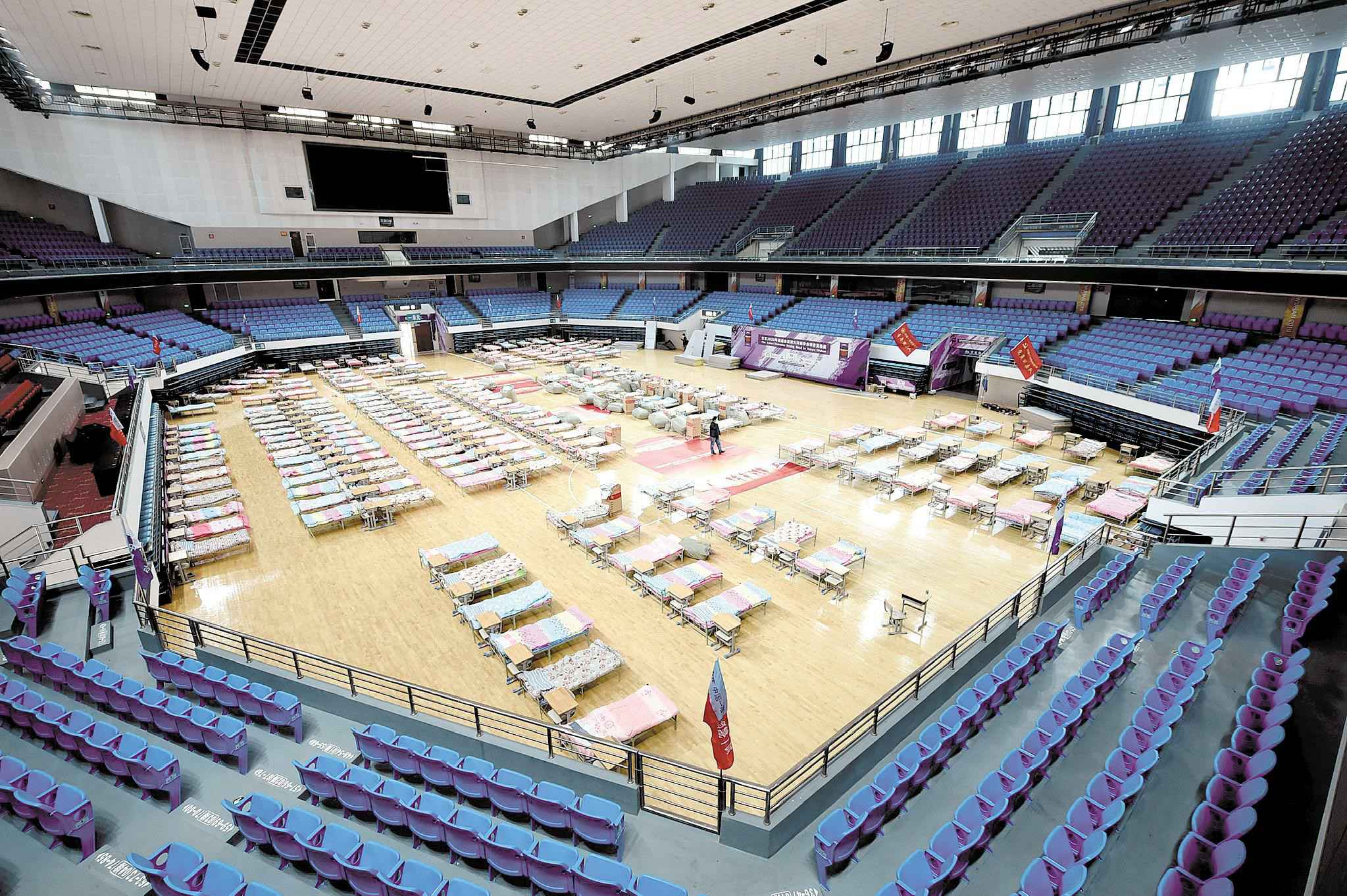 连夜搭建的洪山体育馆“方舱医院”。 (湖北日报全媒记者 李溪 摄) 先期提供万余张床位 “方舱医院”星夜搭建